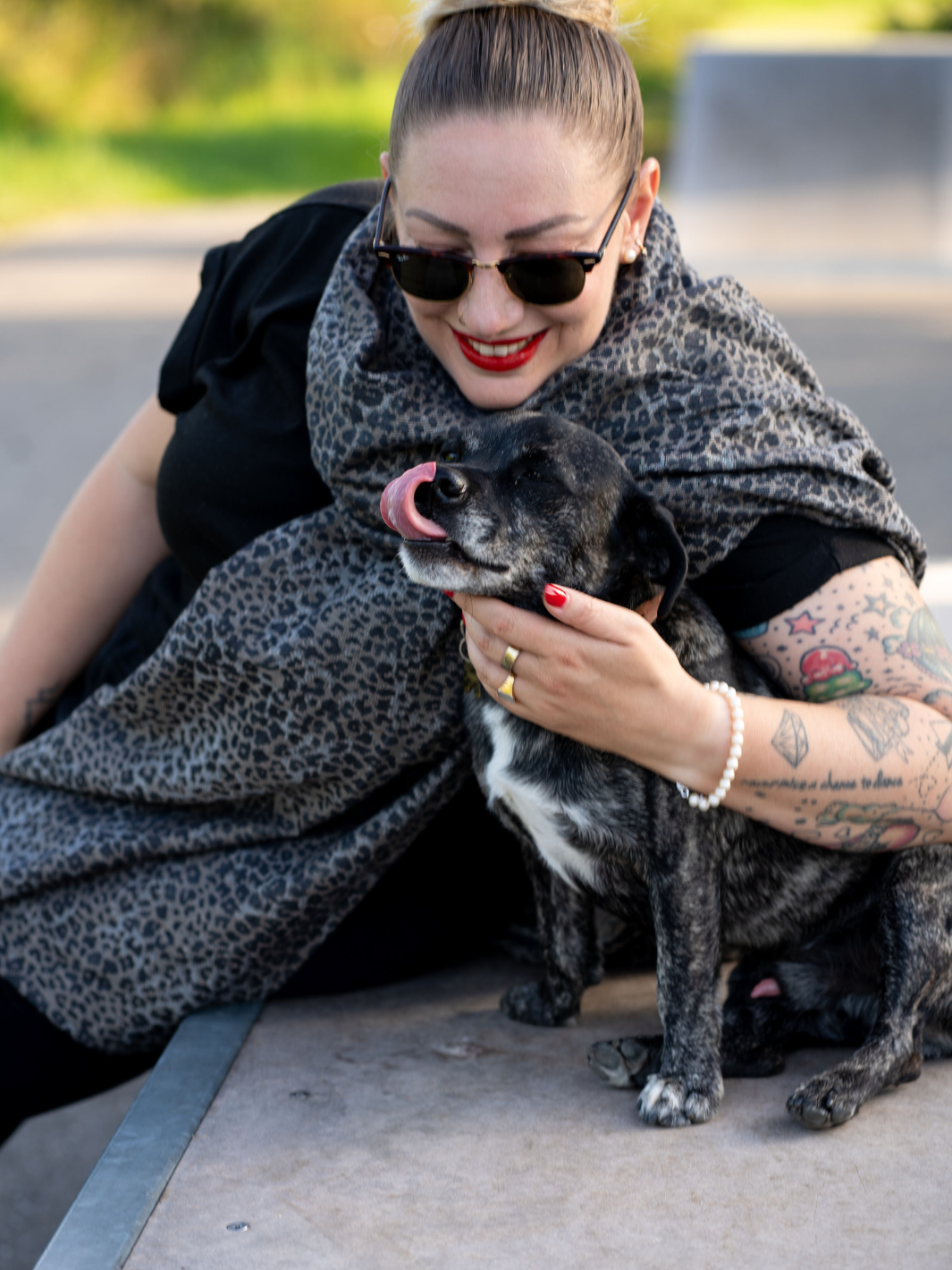 Frau mit Schal von Camilou und einem Hund neben ihr.