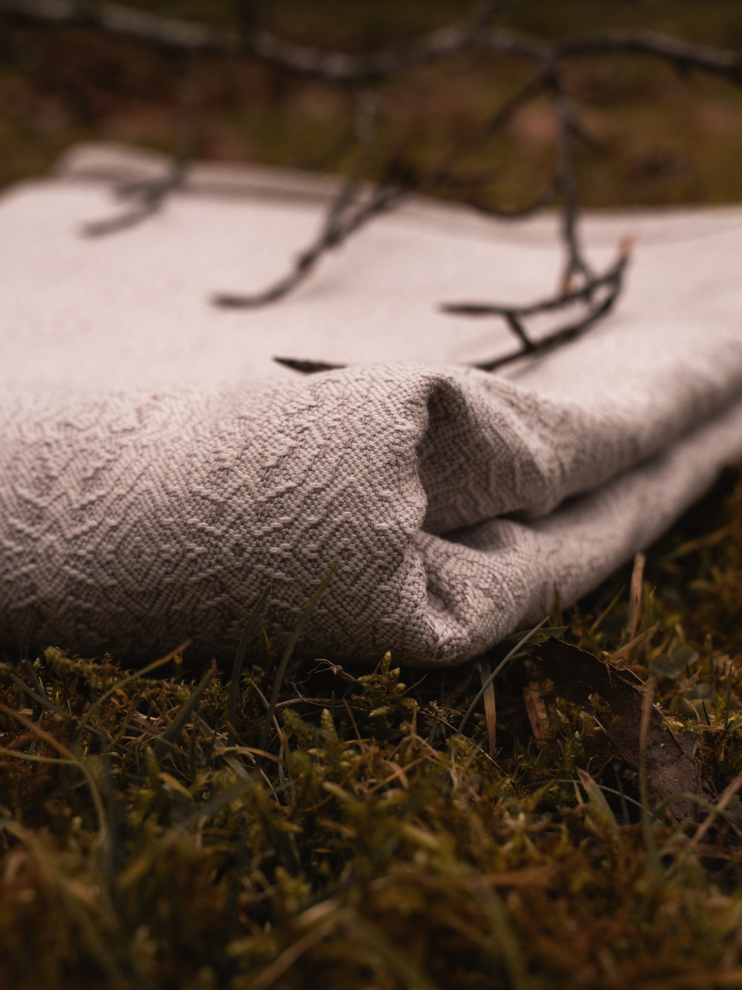 Gefaltetes Tuch auf Moos, Jacquard-Webmuster Detailaufnahme